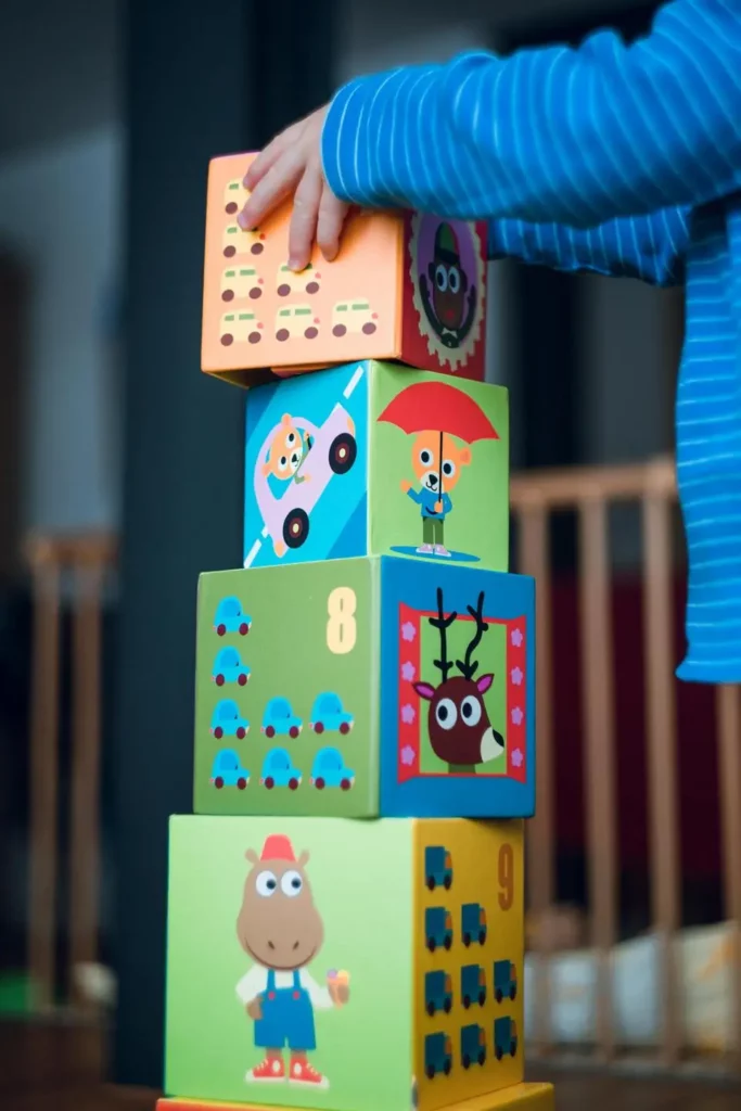 Photographie d'un enfant en évaluation comportementale qui construit une tour avec des cubes